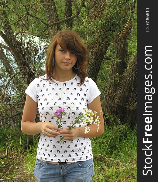 Young girl with wildflowers on tree background