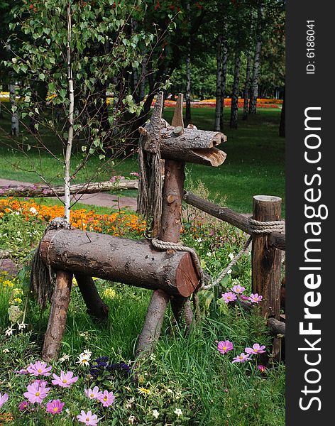 Wooden horsy in a park flower bed