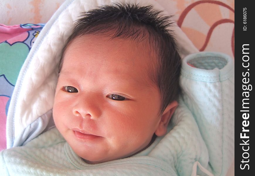 A Chinese baby on a bed. A Chinese baby on a bed