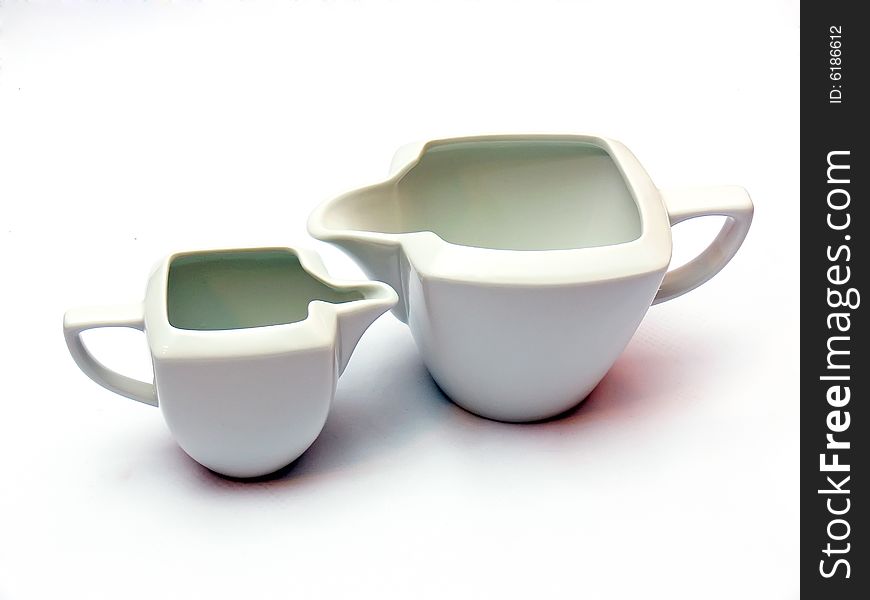 Two white ceramic milk pots isolated on white background.