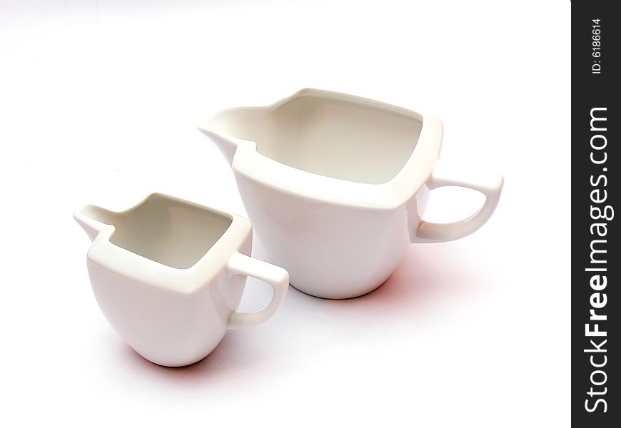 Two white ceramic milk pots isolated on white background.
