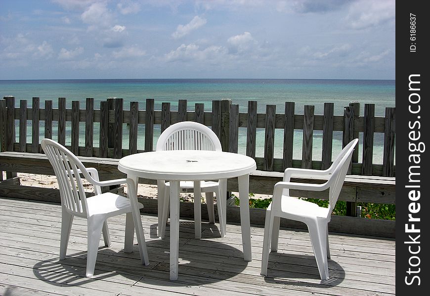 Empty chairs and the table at the beach cafe with a perfect view to Caribbean Sea on Grand Turk Island, Turks & Caicos. Empty chairs and the table at the beach cafe with a perfect view to Caribbean Sea on Grand Turk Island, Turks & Caicos.