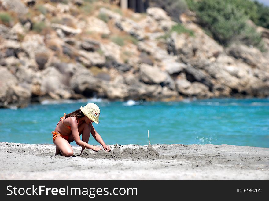 Small girl building sand castles on the beach. Small girl building sand castles on the beach
