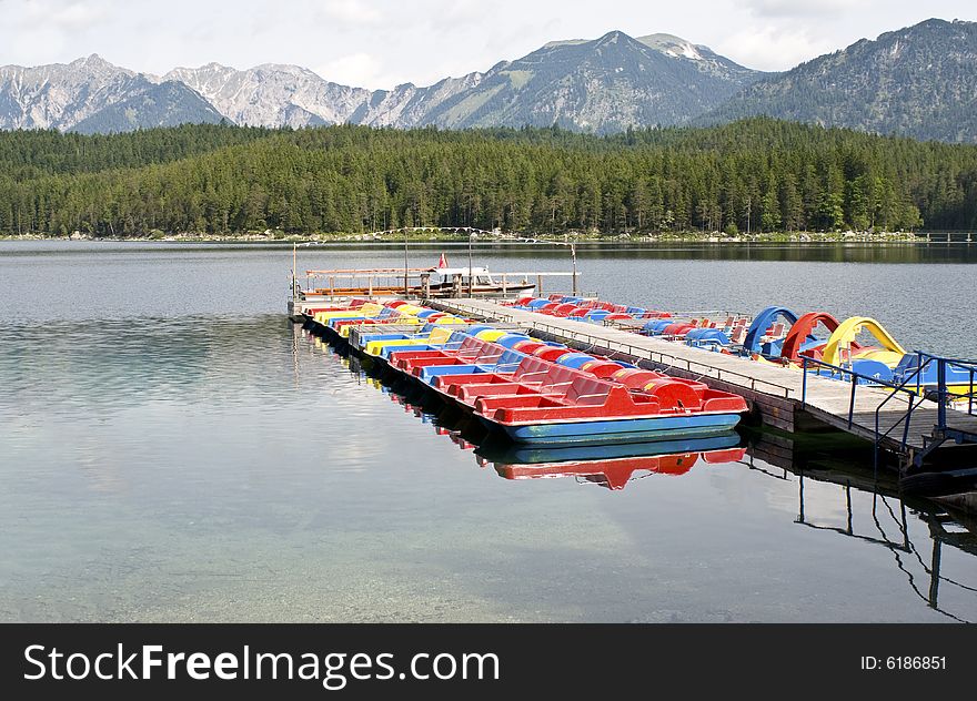 Pedalo boats on a early morning at lake Eibsee, waiting to be rented.
The Eibsee is situated 1000 m about sea level, at the foot of the Zugspitze. Pedalo boats on a early morning at lake Eibsee, waiting to be rented.
The Eibsee is situated 1000 m about sea level, at the foot of the Zugspitze.