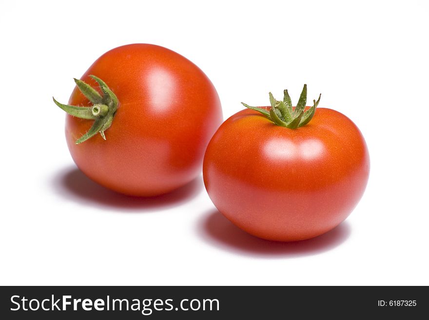 Two vibrant tomatoes on white background. Two vibrant tomatoes on white background
