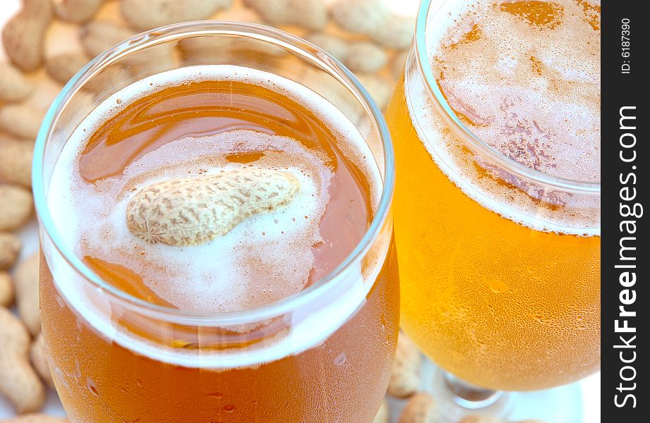 Beer in glass  and  snack - peanuts  in shells. Beer in glass  and  snack - peanuts  in shells.