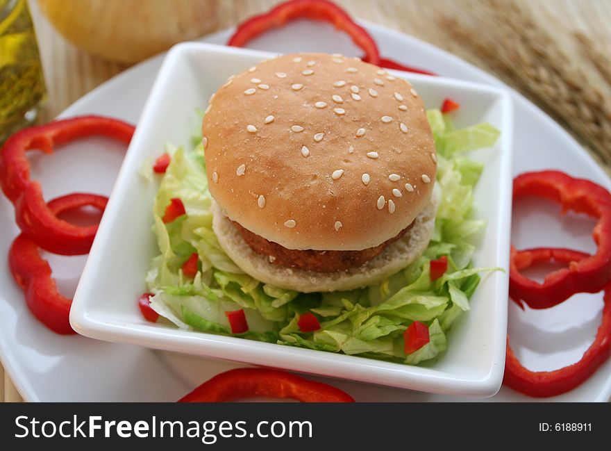 A meal of a little Burger with some salad. A meal of a little Burger with some salad