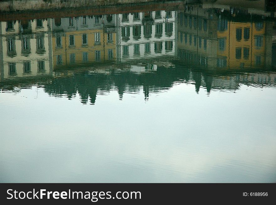 Buildings reflected on the river Arno