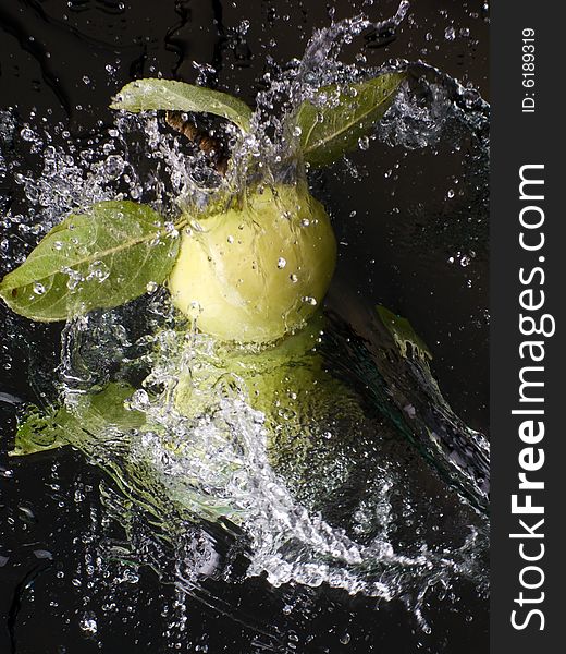 Fresh apple with water splashes on a mirror surface. Fresh apple with water splashes on a mirror surface