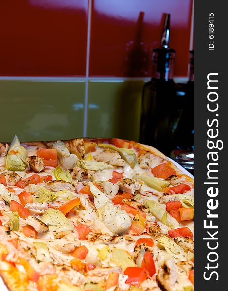 An image of Greek style pizza with artichokes and chicken