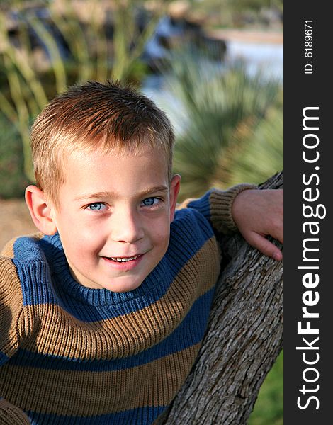 Boy Smiling Leaning on Tree. Boy Smiling Leaning on Tree