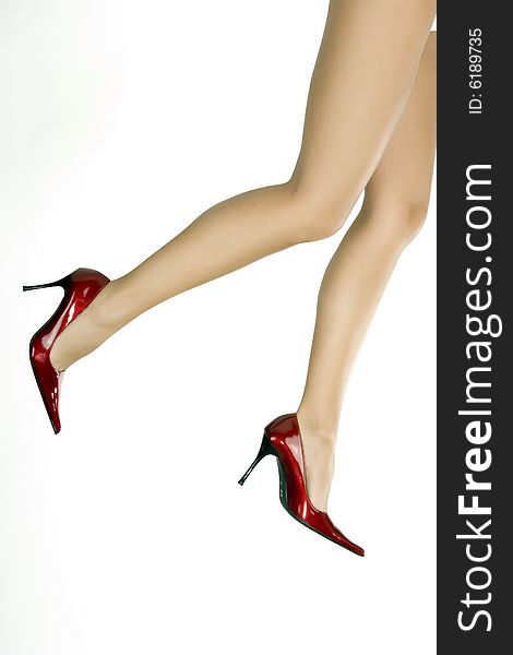 Beautiful legs in red shoes isolated on white background