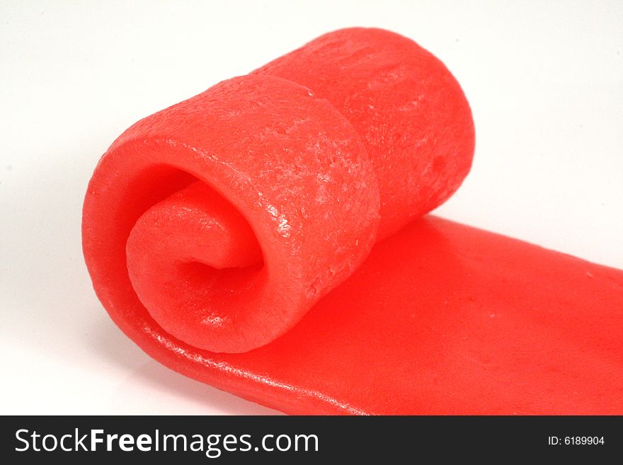 Photo of rolled pink candy against a white background.
