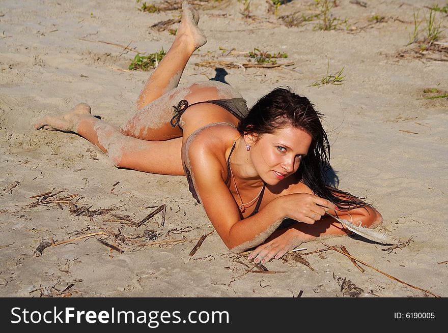 Young lady in bikini plays with bird feather. Young lady in bikini plays with bird feather