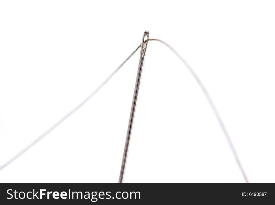 Close up of a needle with thread isolated over white background.