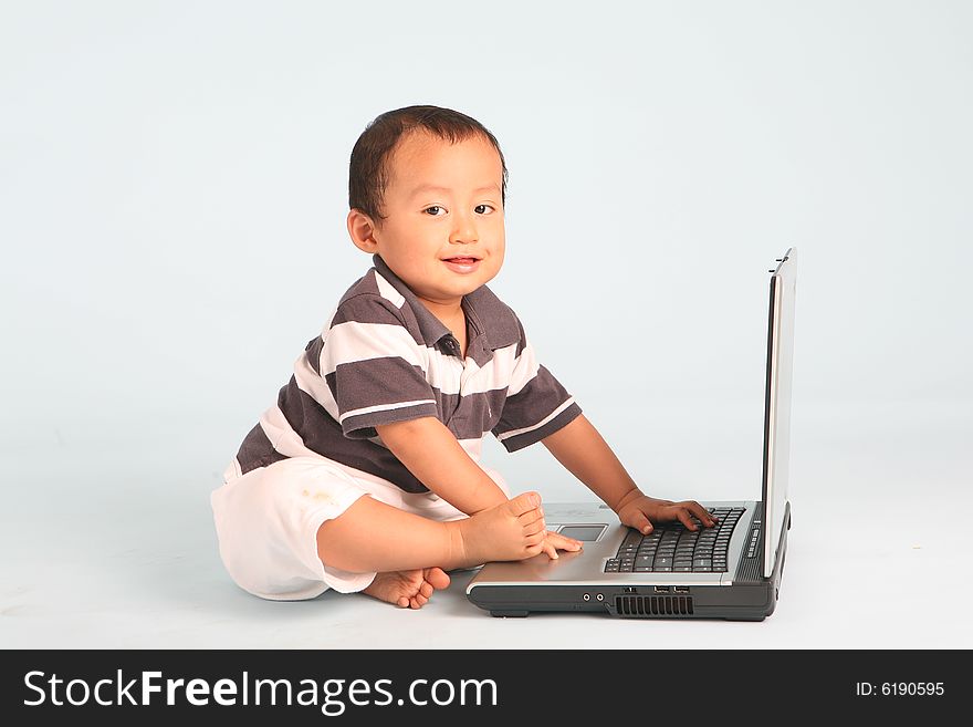 Sleepy toddler using a laptop computer