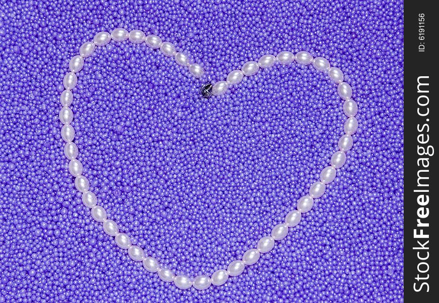 The image heart from pearls beads on a lilac background. The image heart from pearls beads on a lilac background