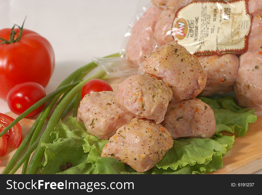 Meatball on the lettuce with tomatoes and green onion
