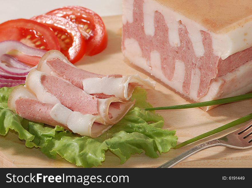 Tasty ham, tomatoes and lettuce on the chopping board. Tasty ham, tomatoes and lettuce on the chopping board