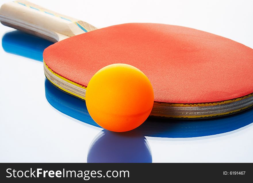 Tennis racket and orange ball on a blue background