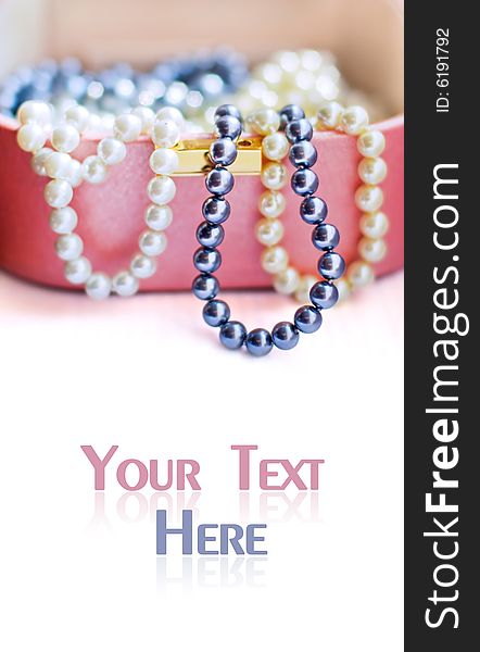 Colorful artificial pearl beads in a chest for jewels with copyspace for your text