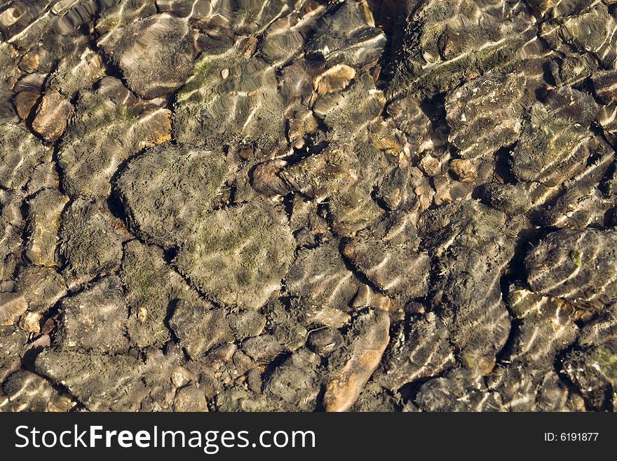 River stones under a water background