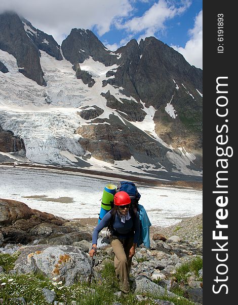 Backpacker girl in helmet climbing on high mountain. Backpacker girl in helmet climbing on high mountain