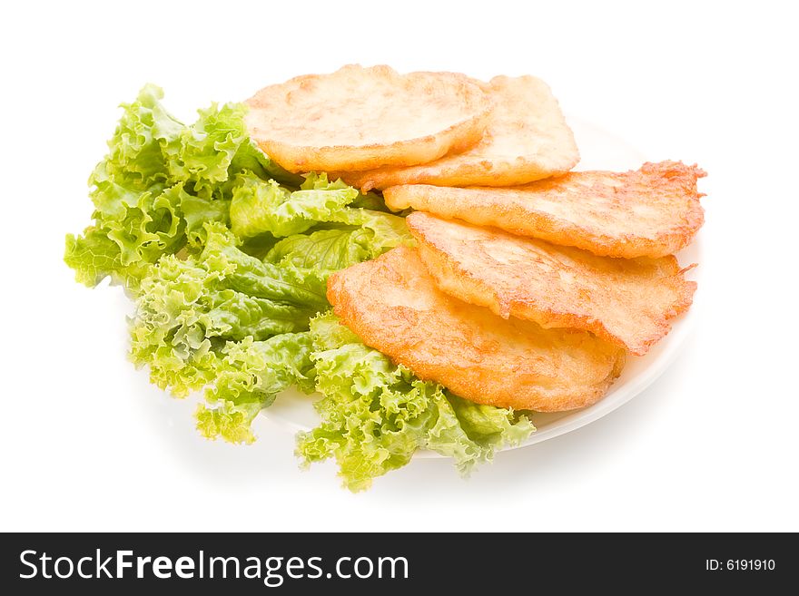 Isolated potato pancakes on the plate with green salad, food photo