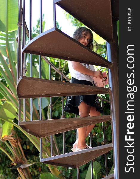 Young girl (almost 7) peeks through the steps of a spiral staircase. Young girl (almost 7) peeks through the steps of a spiral staircase.