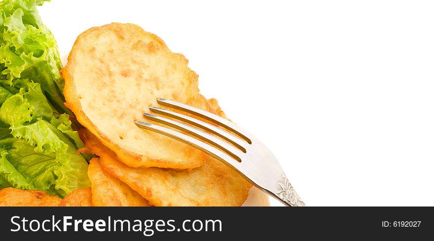 Potato pancakes with green salad and metal fork, left handed position, copy space for the text. Potato pancakes with green salad and metal fork, left handed position, copy space for the text