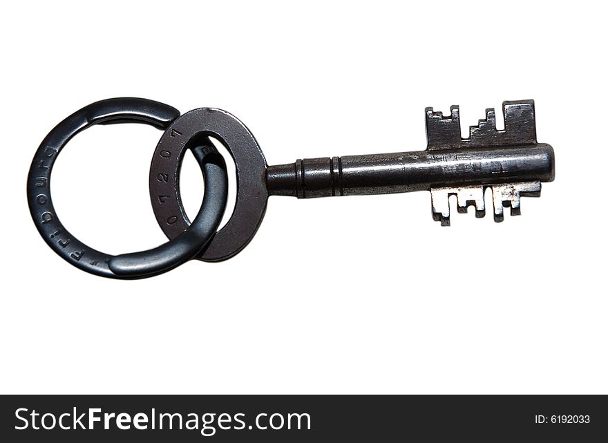 A large antique grey metal key with a key ring attached isolated on white. A large antique grey metal key with a key ring attached isolated on white