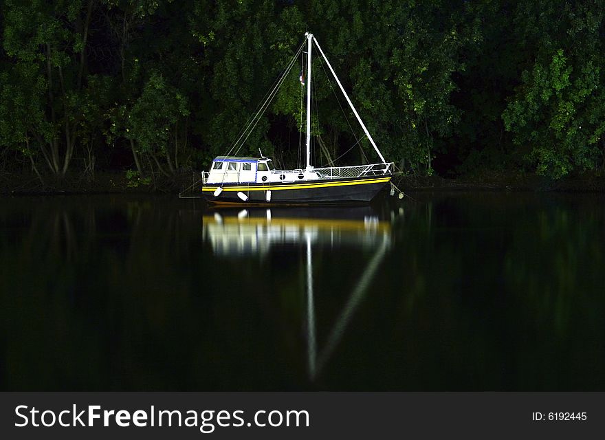 Small boat docked on river by night. Small boat docked on river by night.