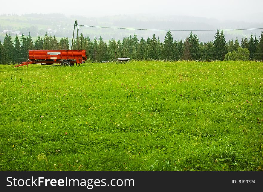 Red trailer on the foggy green hill. Red trailer on the foggy green hill