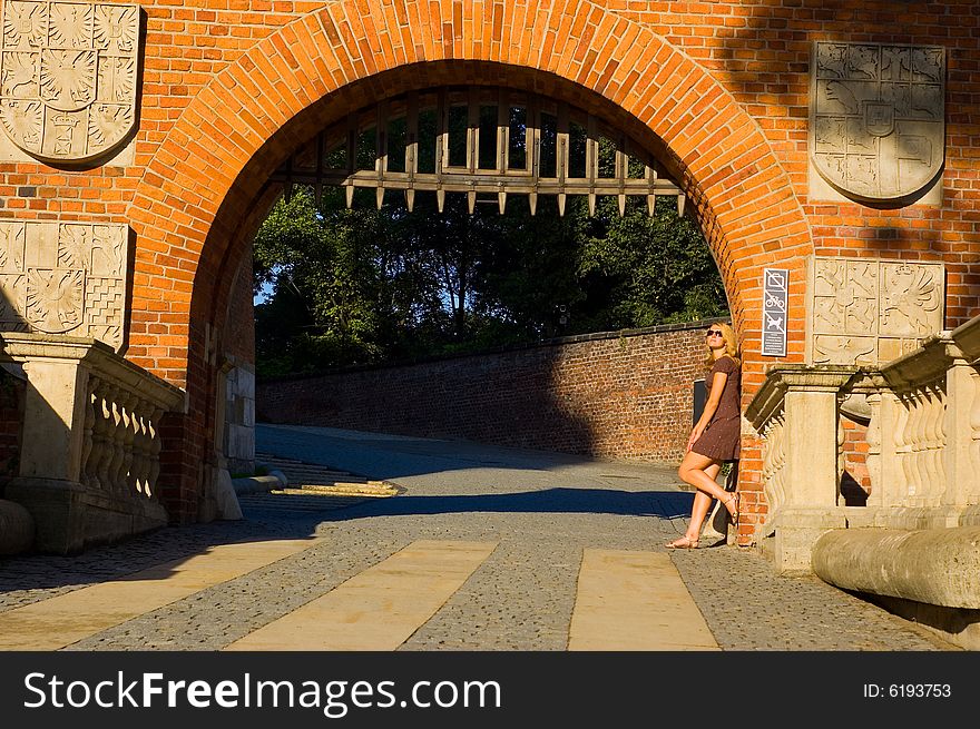 Beautiful young woman near ancient arch in the Krakow. Beautiful young woman near ancient arch in the Krakow