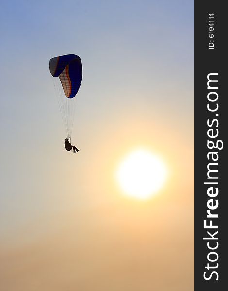 The paraglider pilot against the evening sky