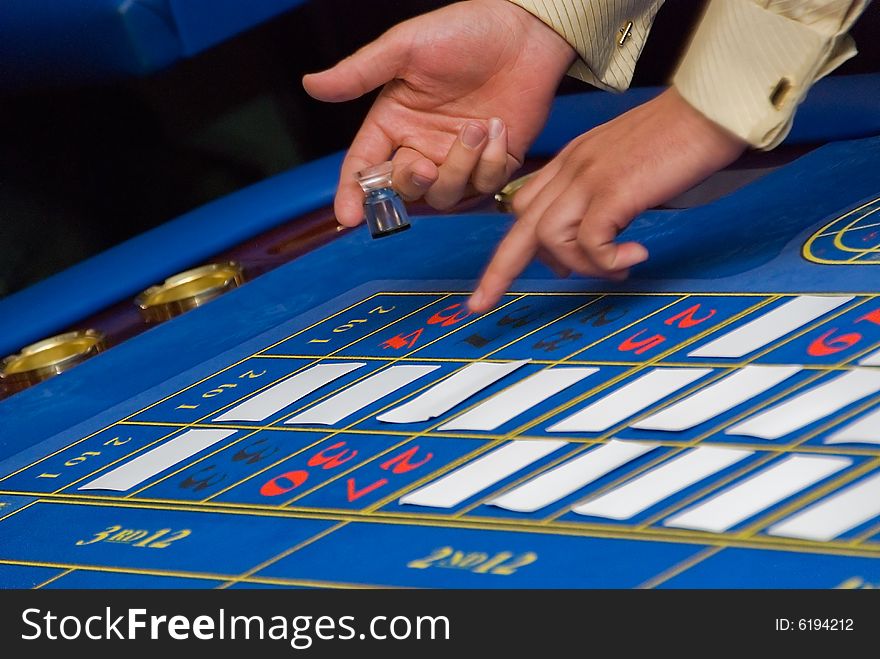 Croupiers hands under the blue roulette table. Croupiers hands under the blue roulette table