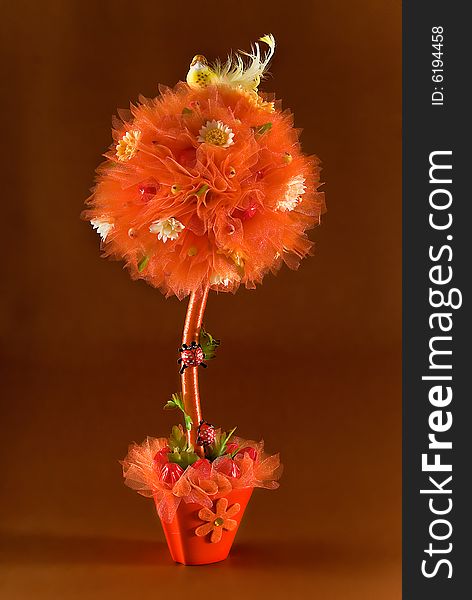 Orange flower with sweets on brown background