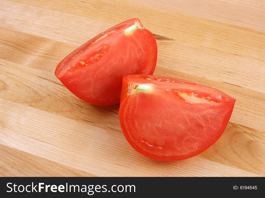 Tomato on wooden kitchen board