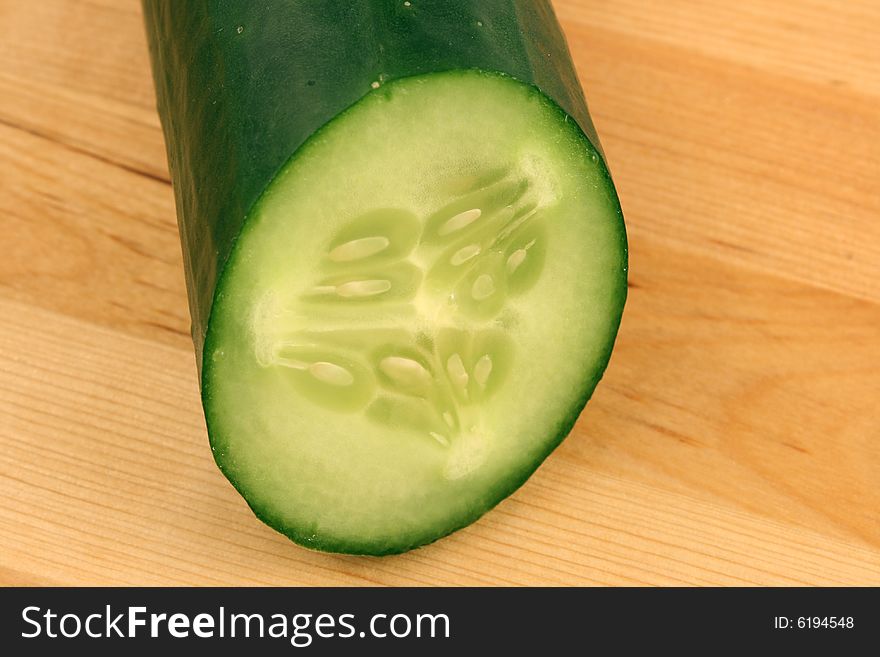 Green cucumber on wooden board