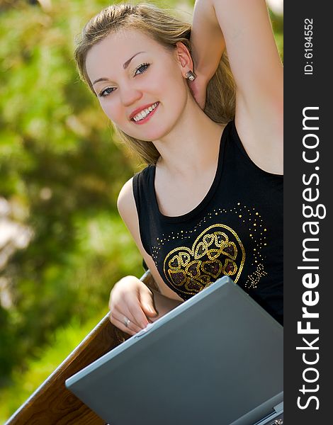 Happy young woman with laptop outdoors shot