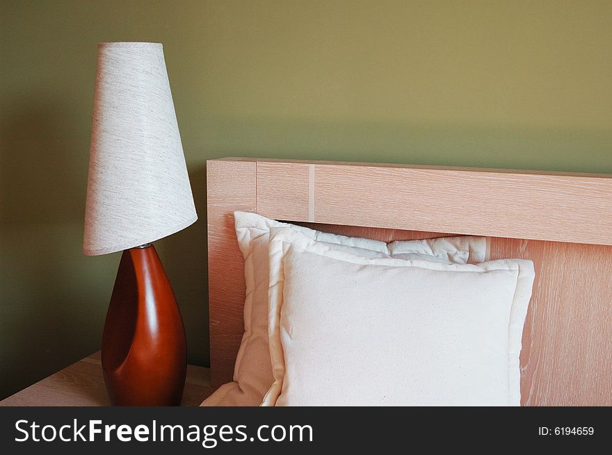 Pastel bedside with pillows and lamp