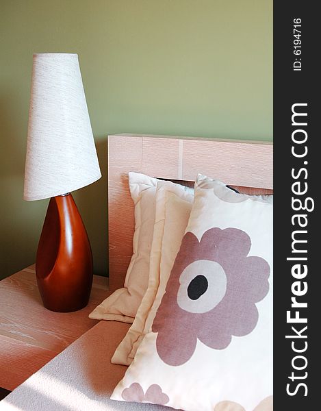 Pastel bedside with pillows and lamp