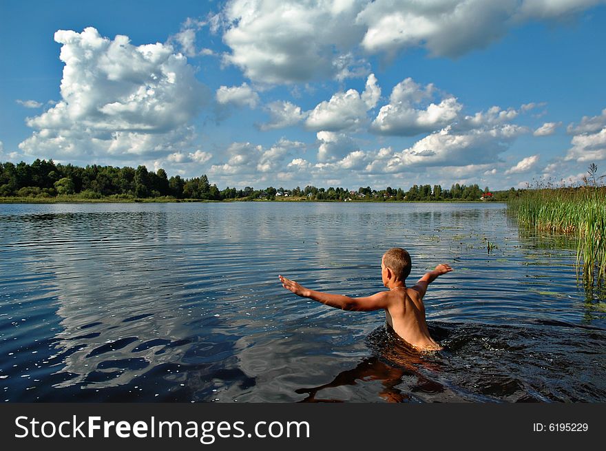 A young boy having a swim in a river on a summer day. A young boy having a swim in a river on a summer day.