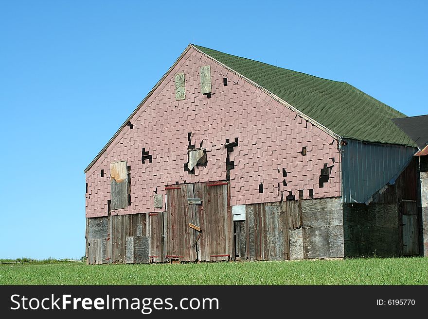A Old barn with grass and blue sky