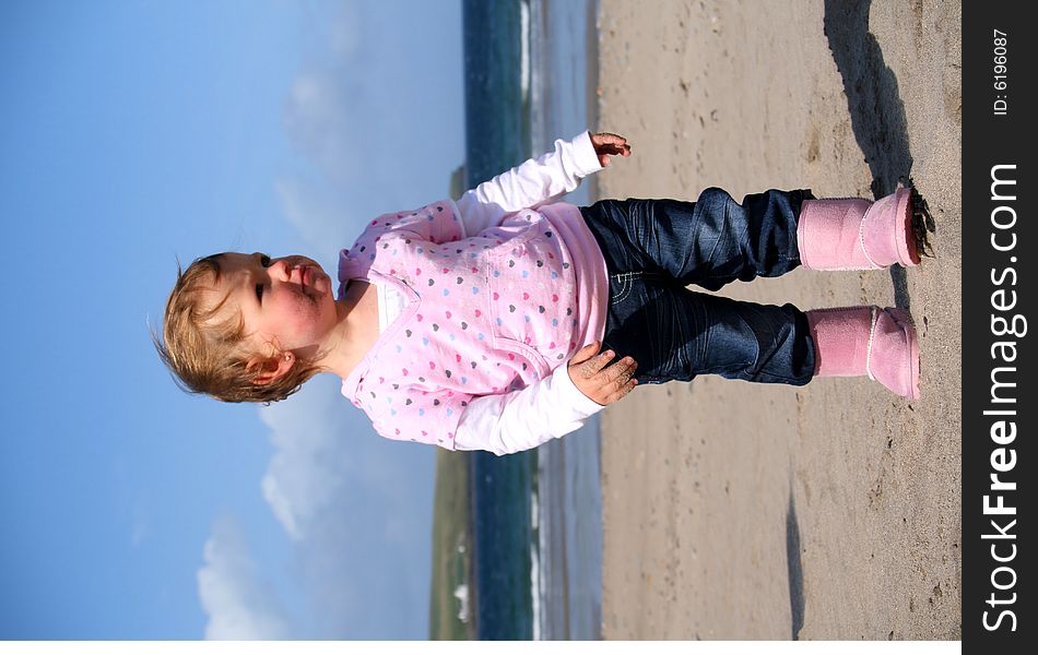 Little girl aged 18 months on the beach exploring the big new world. Little girl aged 18 months on the beach exploring the big new world.