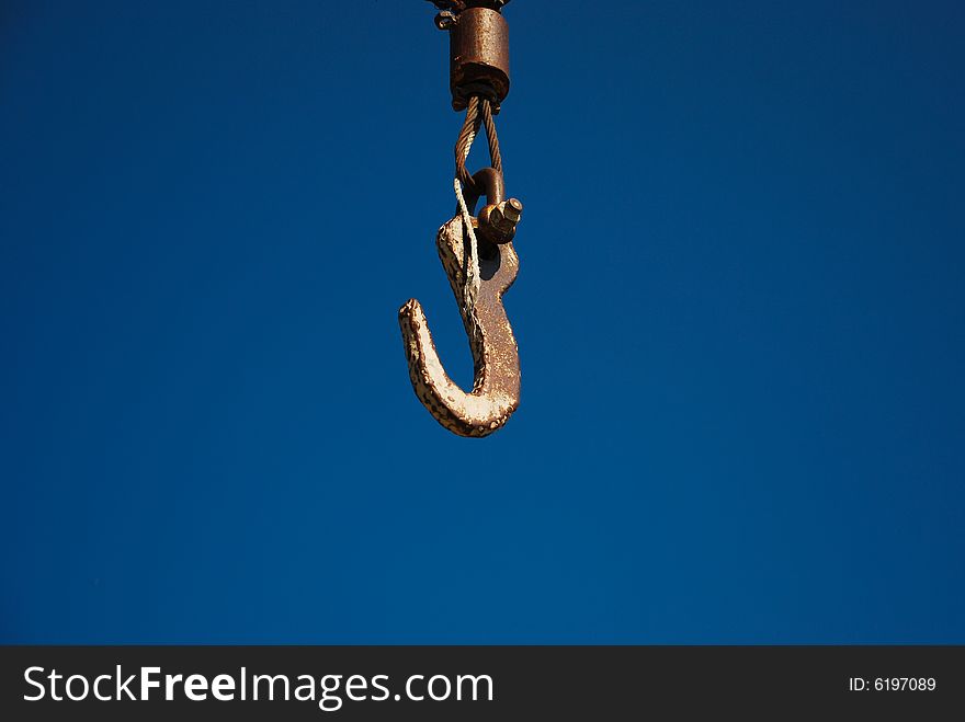 Rusty hook on a blue sky background. Rusty hook on a blue sky background