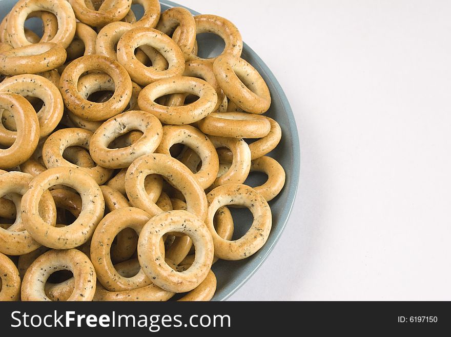 Heap of bread ring in a blue plate on a white background.