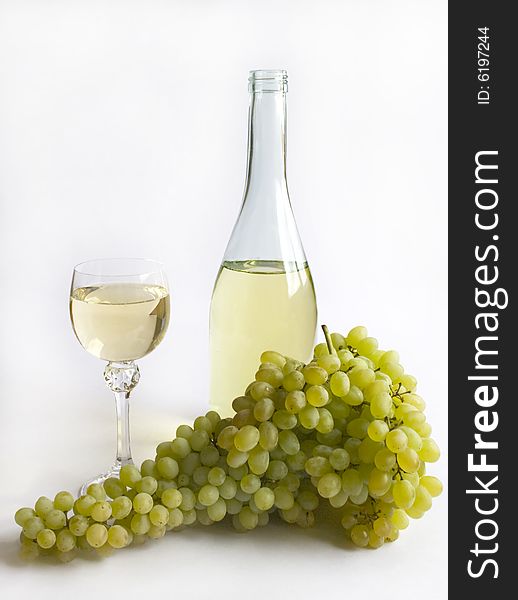 Branch of grapes and white wine in a wineglass. Isolated on White Background.
