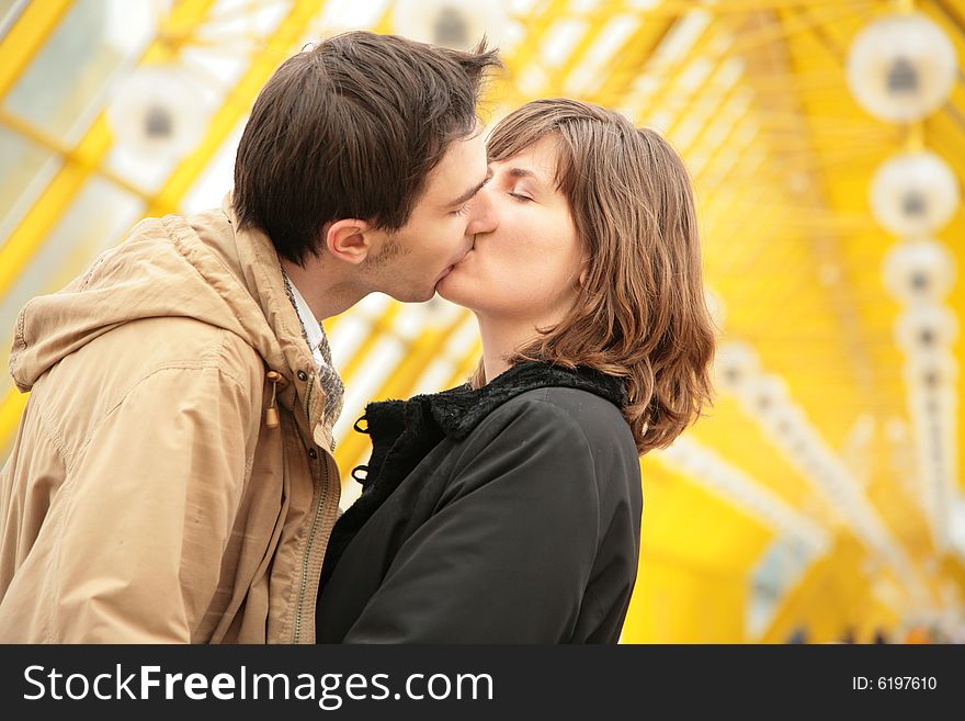 Kissing couple on yellow footbridge