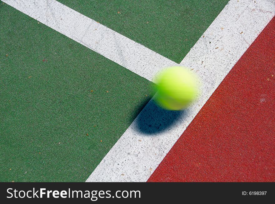 A tennis ball bouncing on the line of a court